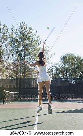 Stock Photograph - Female tennis player mid air. Fotosearch