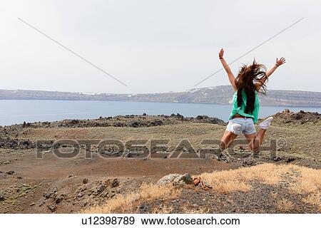 Female tourist jumping mid air, Santorini, Greece View Large Photo Image Stock Photo - Female tourist jumping mid air, Santorini, Greece. Fotosearch
