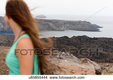 Female tourist looking at volcanic landscape, Santorini, Greece View Large Photo Image Picture - Female tourist looking at volcanic landscape, Santorini, Greece. Fotosearch