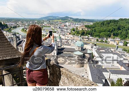Female tourist photographing view of the city, Salzburg, Austria View Large Photo Image Stock Photo - Female tourist photographing view of the city, Salzburg, Austria. Fotosearch