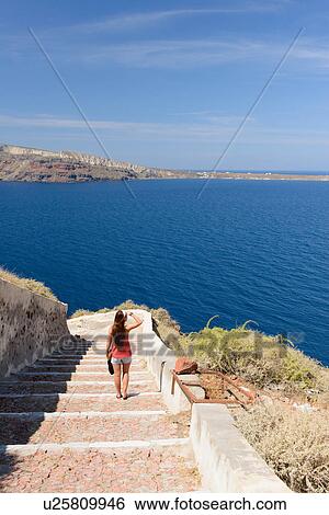 Female tourist walking down steps, Oia, Santorini, Greece View Large Photo Image Stock Photograph - Female tourist walking down steps, Oia, Santorini, Greece. Fotosearch