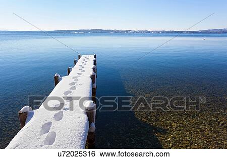 Stock Photograph - Footprints on snow covered pier. Fotosearch