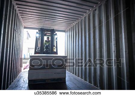 Stock Photograph - Fork lift truck loading boxes into container. Fotosearch