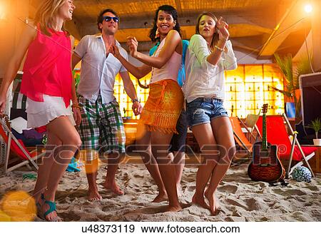 Friends dancing on sand at indoor beach bar View Large Photo Image Stock Photo - Friends dancing on sand at indoor beach bar. Fotosearch