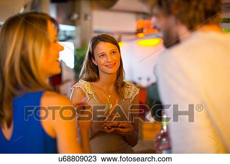 Stock Image - Friends enjoying drinks together in bar. Fotosearch