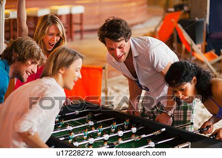 Friends having fun playing table football View Large Photo Image Stock Image - Friends having fun playing table football. Fotosearch