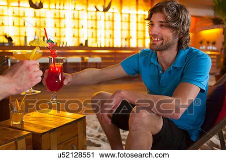 Friends sharing cocktails in bar View Large Photo Image Stock Image - Friends sharing cocktails in bar. Fotosearch