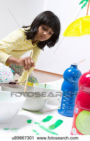 Girl kneeling on floor painting View Large Photo Image Stock Image - Girl kneeling on floor painting. Fotosearch