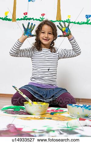 Girl kneeling on floor with painted hands View Large Photo Image Stock Photo - Girl kneeling on floor with painted hands. Fotosearch