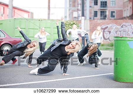 Stock Photo - Girls practicing dance moves in carpark. Fotosearch