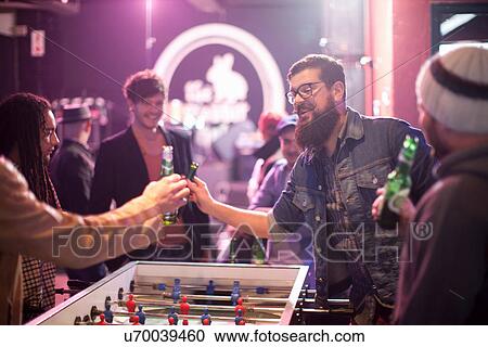 Group of friends and table football game in bar View Large Photo Image Stock Image - Group of friends and table football game in bar. Fotosearch