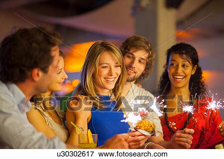 Group of friends enjoying cocktails in bar View Large Photo Image Stock Photo - Group of friends enjoying cocktails in bar. Fotosearch