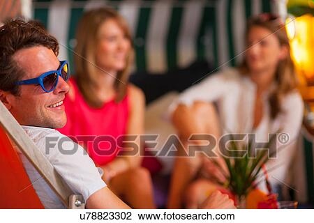 Group of friends enjoying indoor beach party View Large Photo Image Stock Image - Group of friends enjoying indoor beach party. Fotosearch