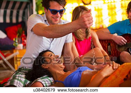 Group of friends having fun at indoor beach party View Large Photo Image Stock Photo - Group of friends having fun at indoor beach party. Fotosearch