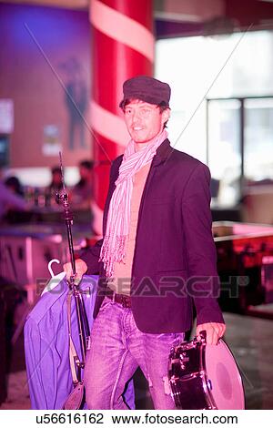 Stock Image - Man carrying musical equipment into club. Fotosearch