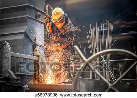 Man in protective clothing at work in steel foundry View Large Photo Image Stock Photograph - Man in protective clothing at work in steel foundry. Fotosearch