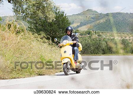 Man on scooter riding around corner View Large Photo Image Picture - Man on scooter riding around corner. Fotosearch