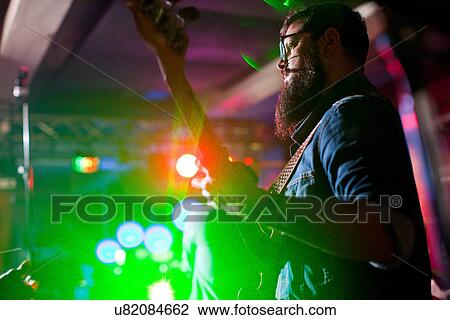 Man playing guitar in nightclub View Large Photo Image Stock Image - Man playing guitar in nightclub. Fotosearch