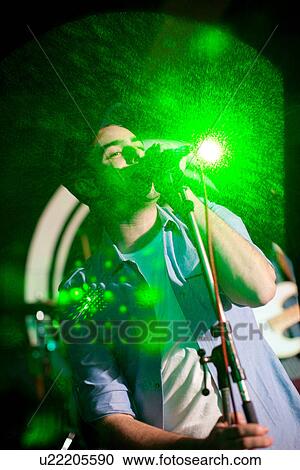 Stock Image - Man singing on stage in nightclub. Fotosearch