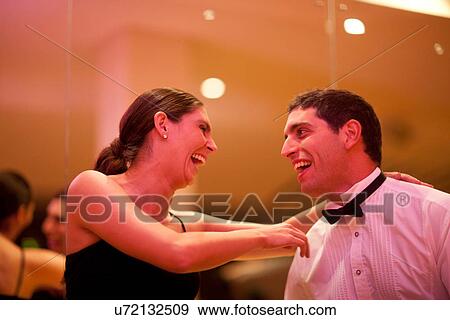 Stock Photo - Mid adult woman and young man laughing in dance class. Fotosearch
