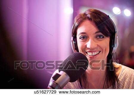 Stock Photo - Mid adult woman broadcasting in recording studio, portrait. Fotosearch