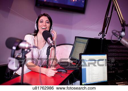 Stock Photograph - Mid adult woman broadcasting in recording studio, portrait. Fotosearch