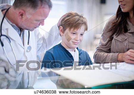 Stock Photo - Mother and son with doctor at hospital reception. Fotosearch