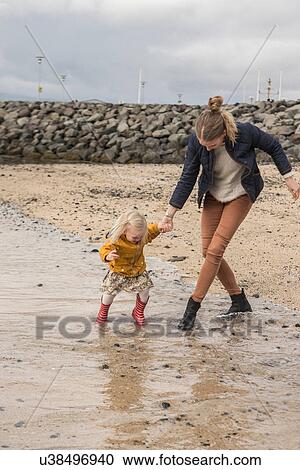 Mother and toddler walking at waters edge View Large Photo Image Stock Image - Mother and toddler walking at waters edge. Fotosearch