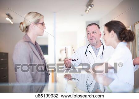 Stock Image - Nurse and doctor in hospital reception. Fotosearch