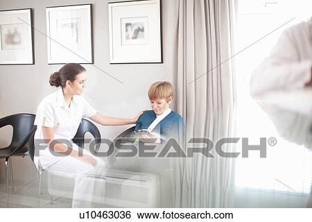 Nurse chatting to young patient in hospital reception View Large Photo Image Stock Photograph - Nurse chatting to young patient in hospital reception. Fotosearch
