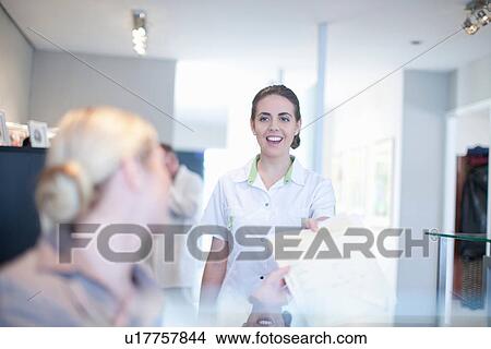 Nurse handing file to hospital receptionist View Large Photo Image Picture - Nurse handing file to hospital receptionist. Fotosearch