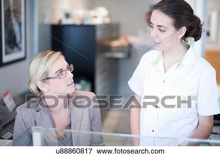 Nurse talking to hospital receptionist View Large Photo Image Stock Photo - Nurse talking to hospital receptionist. Fotosearch