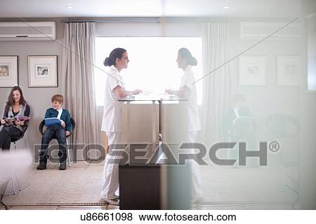 Stock Photo - Nurse waiting at hospital reception desk. Fotosearch