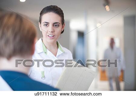 Nurse with patient and notes in reception View Large Photo Image Stock Image - Nurse with patient and notes in reception. Fotosearch