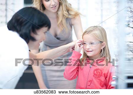 Optician guiding young girl on choice of eyeglasses View Large Photo Image Stock Image - Optician guiding young girl on choice of eyeglasses. Fotosearch