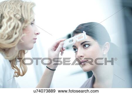 Stock Photo - Optician testing patient in eye clinic. Fotosearch