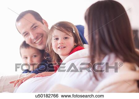 Parents and young two children lounging on bed View Large Photo Image Stock Photograph - Parents and young two children lounging on bed. Fotosearch
