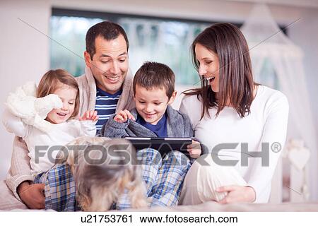 Parents, two children and dog looking at digital tablet View Large Photo Image Stock Image - Parents, two children and dog looking at digital tablet. Fotosearch