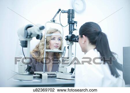 Stock Image - Patient and optician in eye clinic. Fotosearch