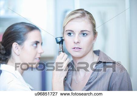 Patient having ear examined by doctor View Large Photo Image Stock Photo - Patient having ear examined by doctor. Fotosearch