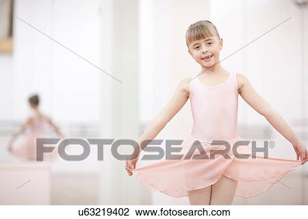 Stock Image - Portrait of a young ballerina holding skirt. Fotosearch