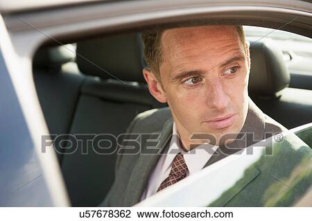 Portrait of businessman in back seat of car View Large Photo Image Stock Image - Portrait of businessman in back seat of car. Fotosearch