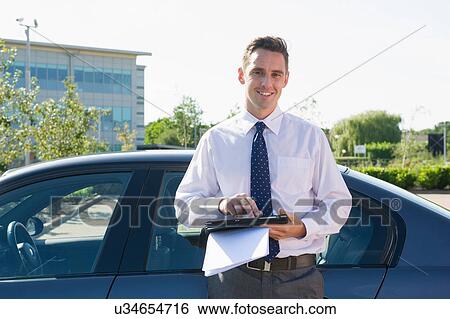 Portrait of businessman using computer tablet in office car park View Large Photo Image Stock Photograph - Portrait of businessman using computer tablet in office car park. Fotosearch