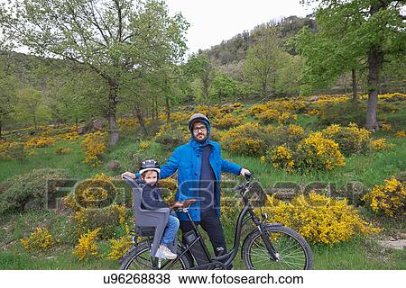 Stock Photo - Portrait of father and young daughter on bike. Fotosearch
