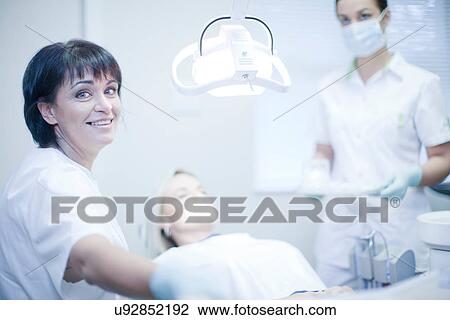 Portrait of female dentist with nurse and patient View Large Photo Image Stock Image - Portrait of female dentist with nurse and patient. Fotosearch
