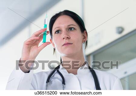 Portrait of female doctor holding up syringe View Large Photo Image Stock Image - Portrait of female doctor holding up syringe. Fotosearch