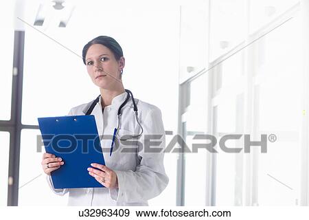 Stock Photo - Portrait of female doctor with clipboard. Fotosearch