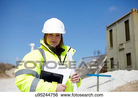 Portrait of female with blueprint and digital tablet on construction site View Large Photo Image Stock Photograph - Portrait of female with blueprint and digital tablet on construction site. Fotosearch