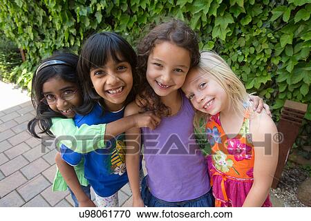Stock Image - Portrait of four girls hugging. Fotosearch