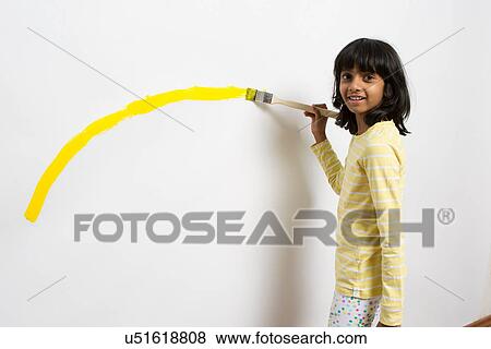 Portrait of girl painting yellow curve on wall View Large Photo Image Stock Photo - Portrait of girl painting yellow curve on wall. Fotosearch